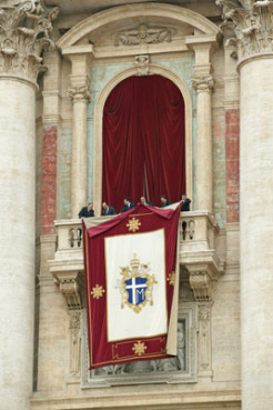 Workers hang out a papal banner from the balcony on St. Peter's Basilica in the Vatican before new Pope Benedict XVI waved to the crowd. Photo by Grzegorz Galazka.