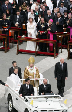In a dramatic ending to the outdoor Mass that officially launched his papal reign, Pope Benedict XVI drove through St. Peter's Square standing in an open-topped jeep, a visual contrast to the bullet-proof ``popemobile'' that his predecessor, Pope John Paul II, used after being targeted by an assassin in 1981. A slight figure in gold brocade vestments and mitre, Benedict XVI gave his blessing as church bells rang, the music of Bach resounded from an organ inside St. Peter's Basilica and pilgrims cheered and waved flags. Behind the pope are Spain's King Juan Carlos and Queen Sofia. Photo by Grzegorz Galazka.