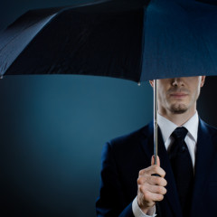 Portrait of a man in a suit with an umbrella courtesy Shutterstock