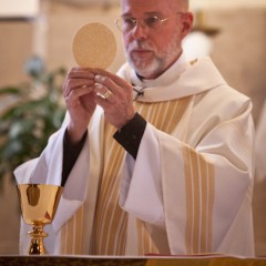 Father Ernie Davis blesses the communion during Catholic mass at St. Therese Little Flower parish in Kansas City, Mo. RNS file photo by Sally Morrow.