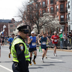 A Police officer stands by as runners pass during the 2013 Boston Marathon. Photo courtesy Sonia Su via Flickr (http://flic.kr/p/ebzEmM)