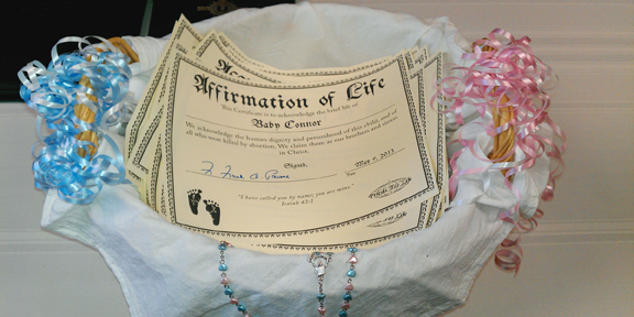 The Rev. Frank Pavone of the anti-abortion group Priests for Life dedicated a basket of naming certificates for 47 babies who died in the Philadelphia clinic of Dr. Kermit Gosnell. RNS photo courtesy Andre Kim/Priests for Life.